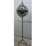 An encased spherical hinged basket Gimble lamp? hung in a floorstanding steel frame, 124 cm high