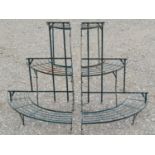 A pair of green painted light steel corner plant stands on three graduated bow fronted tiers, 75