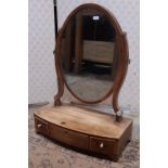 A Georgian mahogany toilet mirror with oval mirror plate, box base