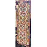 A Chobi Kilim runner with a repeating multi coloured geometric pattern, 254cm x84cm approx.