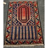 An Old Baluchi rug with a rhombic stepped medallion flanked by stylised flowers,134cm x 90cm approx