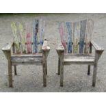 A pair of painted and weathered teak garden open armchairs with tapered slatted backs, 76 cm wide (