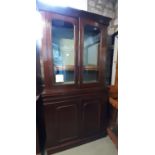 A late Victorian mahogany library bookcase enclosed by two pairs of doors, one panelled one glazed