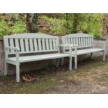 A pair of light green painted soft wood three seat garden benches with slatted seats and backs