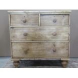 A stripped pine chest of two long and two short drawers on turned supports