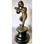 A spelter statue of a young girl doing a jig and playing a tambourine, raised on a socle base,