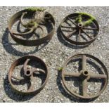 Four antique cast iron implement wheels of varying size and design, the largest example 53 cm in