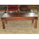 An Indian hardwood occasional table on turned supports with further steel banded borders, 115 cm