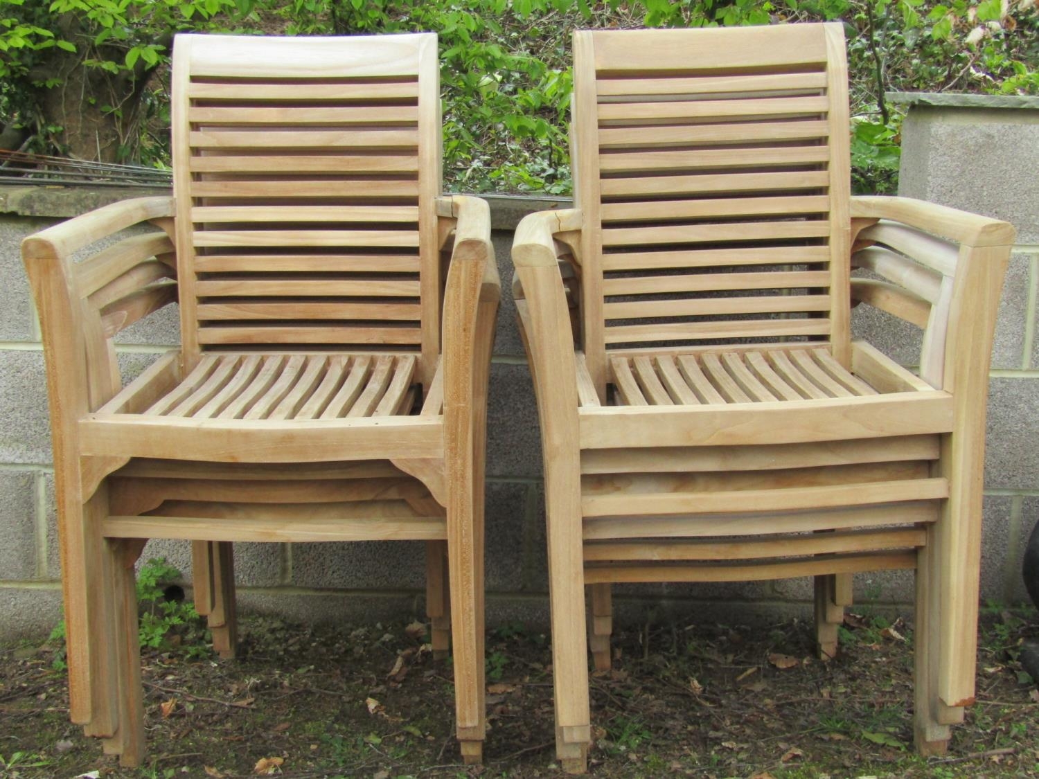 Eight partially weathered teak garden open armchairs with slatted seats and backs