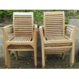 Eight partially weathered teak garden open armchairs with slatted seats and backs