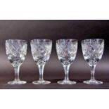 Four Victorian style thistle cut glass wine glasses on faceted stems.