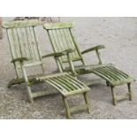 A pair of well weathered teak folding garden steamer type lounge chairs with slatted seats, backs