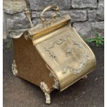 A Victorian brass coal scuttle and shovel with shaped outline and applied detail on scrolled