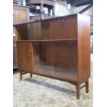 A mid 20th century teak cabinet, partially enclosed by sliding plate glass door, solid doors and