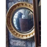 A Regency convex mirror in a typical black and gilt moulded framework, 58cm diameter