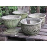 Two pairs of weathered circular garden planters with repeating foliate detail (varying design),