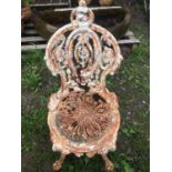 A weathered heavy gauge Victorian cast iron garden chair with circular seat and decorative pierced