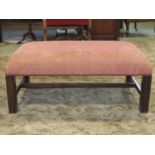 A Georgian style upholstered centre stool on square moulded supports, 90cm max