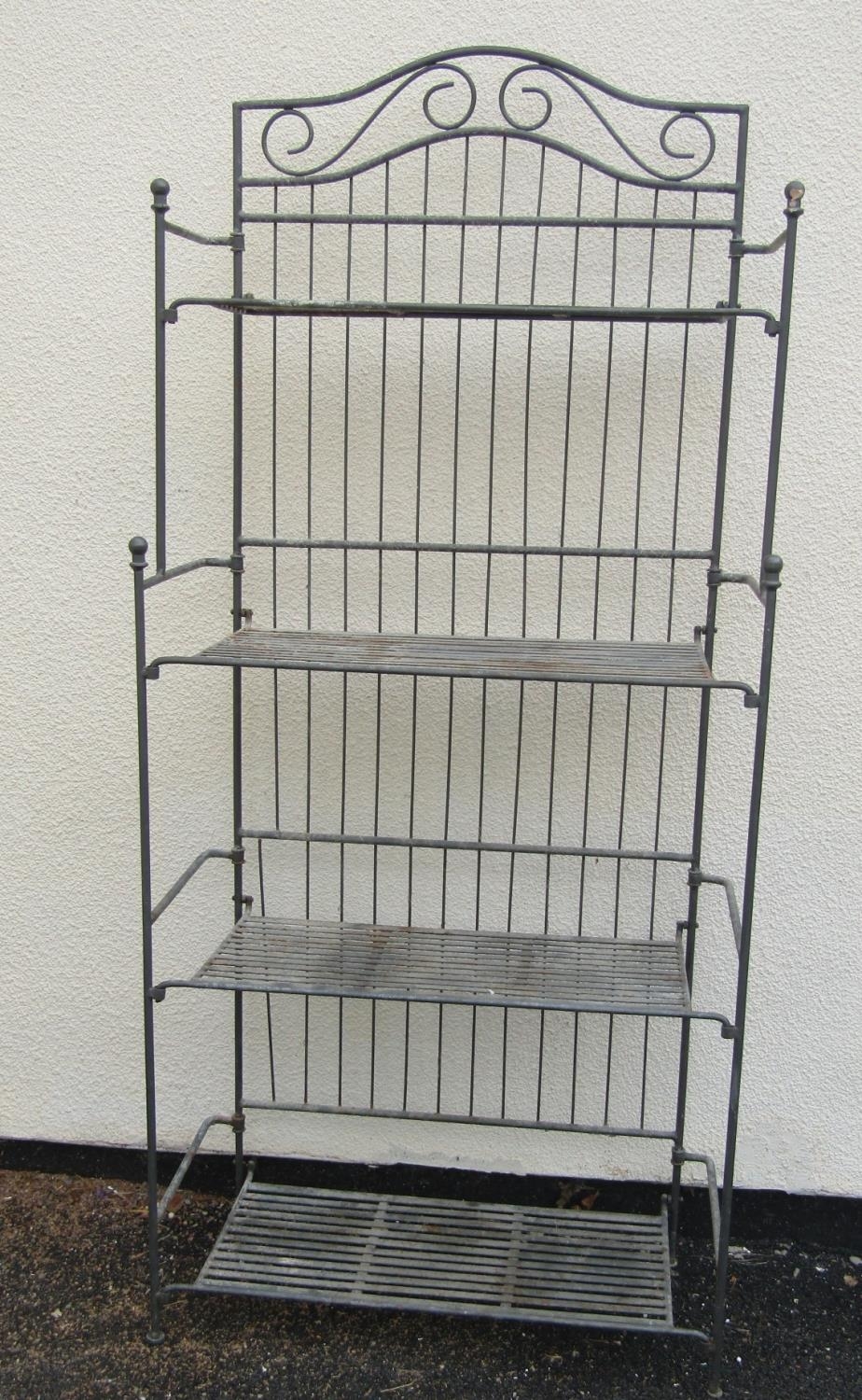 A heavy gauge freestanding folding steel rack with four partially graduated strapwork tiers, 83 cm