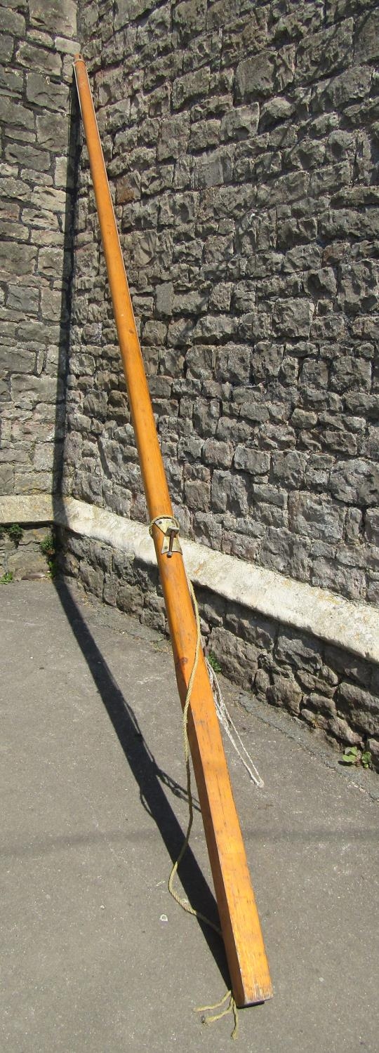 A stained pine mast/flag pole, 4 metres long