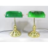 A pair of brass clerks lamps with tilting green glass shades