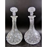 A pair of rounded cut glass decanters and a third similar, with a single hallmarked silver Madeira