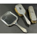 A silver hand mirror, clothes brush and hair brush (3)