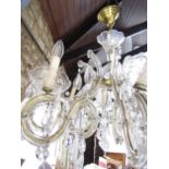 A Regency style eight branch brass and glass chandelier festooned with facetted droplets.