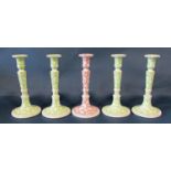 Five ceramic candlesticks with scrolling printed decoration, four in green, one in red, 28cm tall