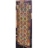 A Chobi Kilim runner with a repeating multi coloured geometric pattern, 254cm x84cm approx.