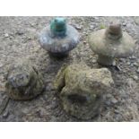 A small collection of weathered cast composition stone garden ornaments in the form of frogs, two