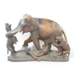 A South East Asian wood carving of an elephant fighting off three tigers 35 cm wide x 25 cm high