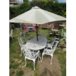 A cream painted cast aluminium garden terrace table of oval form with decorative pierced and foliate