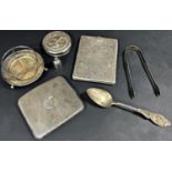 A richly engraved silver cigarette case, a curved cigarette case, sugar tong, teaspoon, two silver