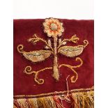 An ecclesiastic altar cover with crimson upper surface cloth and adjoining pink velvet fringed