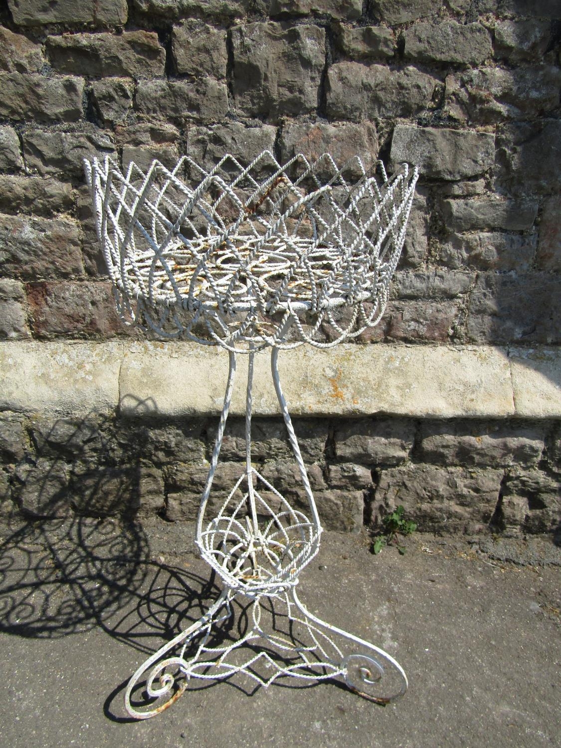 A vintage wirework plant stand raised on scrolled supports, 84 cm high