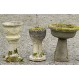 Three weathered cast composition stone circular planters raised on squat pedestals (varying size and