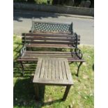 A two seat garden bench with weathered wooden slatted seat, cast lattice panelled back and