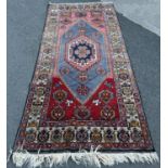 A Kazak carpet with n elongated stepped lozenge medallion and a stylised floral border, 220cm x