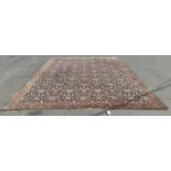 A large Middle Eastern style carpet with an all over floral pattern on a black field (repaired and