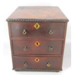 A 19th century mahogany apprentice’s chest of drawers with three long drawers on bun feet, 23.5cm