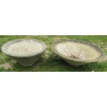 Two weathered squat conical shaped planters of varying size and design, the larger example 60 cm