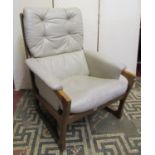 A mid 20th century armchair, the moulded teak frame with exposed jointed arms, soft leather pad