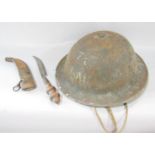 A rusty military tin helmet with original head padding and chin strap and a crude curved dagger in a