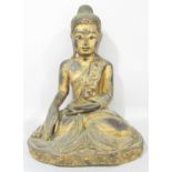A Tai wooden carved figure of buddha depicted in the dhyansana position in a worn gold finish with