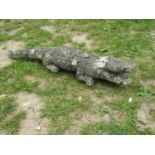 A weathered cast composition stone garden ornament in the form of an alligator 80 cm long