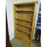 A contemporary light oak floorstanding open bookcase with four adjustable shelves over two drawers