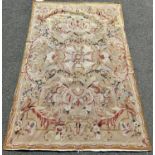 Two Aubusson style wall hangings, one with an all over rose pattern on a fawn ground, the other,