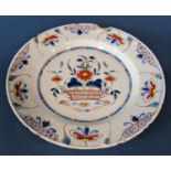 An 18th century English Delft tin glazed earthenware plate centrally decorated with a basket of