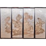 An oriental four fold freestanding screen with lacquered frame enclosing embroidered panels